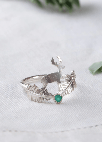 Amanda Coleman's stag and fern ring with an emerald stone