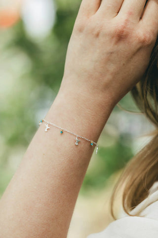 This is a mini hummingbird and flowers charm bracelet, handmade in solid 925 sterling silver in the UKwith clusters of 22ct gold vermeil flowers decorated with turquoise stones.