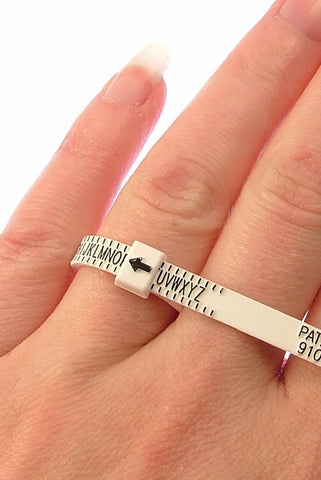 image of a white ring sizer on someone's hand