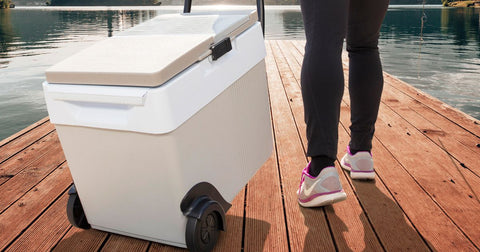 Photo of a person pulling the W65 wheeled cooler on a wooden dock
