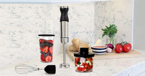 Kenmore immersion blender set with whisk and food chopper attachments and blending jar with storage lid on a white and gray marble counter with fruits and vegetables arranged around