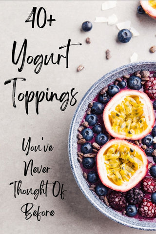 Photo shows the left half of a shallow blue bowl filled with yogurt, frozen berries, sunflower seeds, and two passionfruit halves, on a light gray surface. Text overlay reads 40+ Yogurt Toppings You've Never Thought of Before