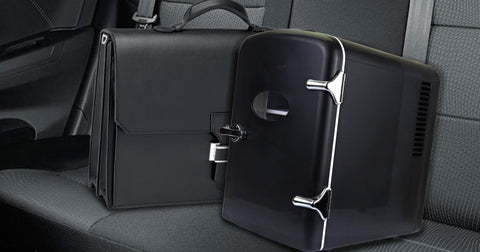 Photo of black 4 L mini fridge on the black leather back seat of a vehicle beside a black leather briefcase