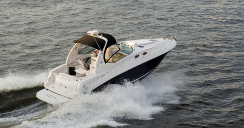 Picture of a powerboat motoring across a large expanse of water with water spraying up on either side