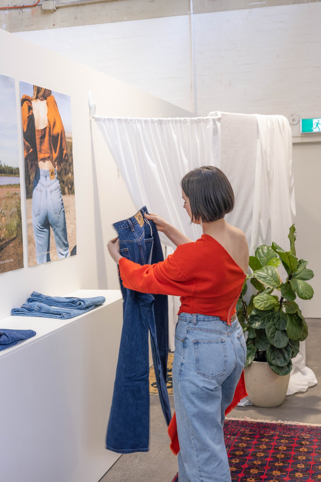 Brianna Murphy holding HERA Denim jeans at the pop-up shop in Geelong's Boom art Gallery