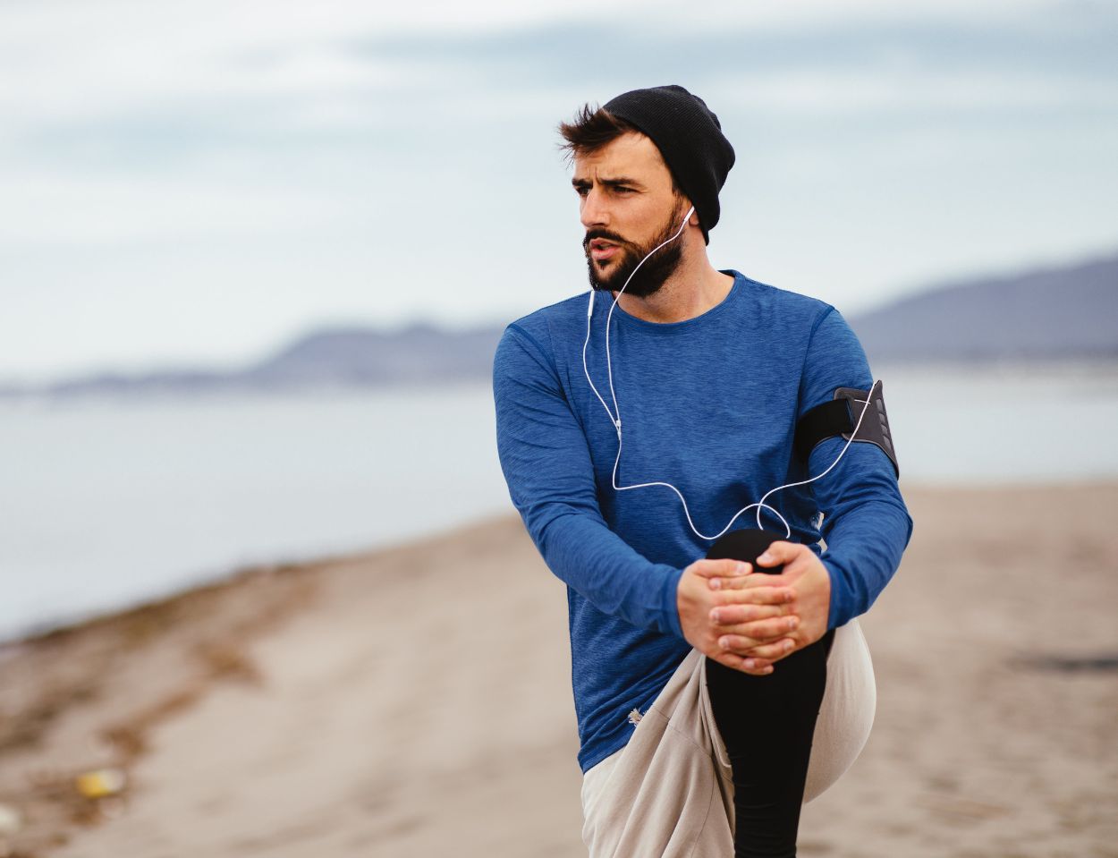 Bild eines Läufers in einer Dehnpose, symbolisiert aktiven Lebensstil und Fitness, passend für eine Webseite, die sich auf Sport- und Wellnessprodukte konzentriert.