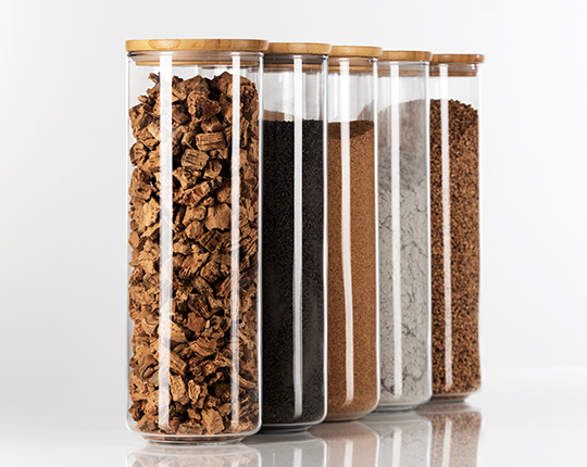 Raw materials of cork and clay in glass display cannisters