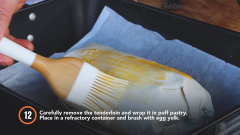 Step 12: Carefully remove the tenderloin and wrap it in puff pastry. Place in a refractory container and brush with egg yolk. 