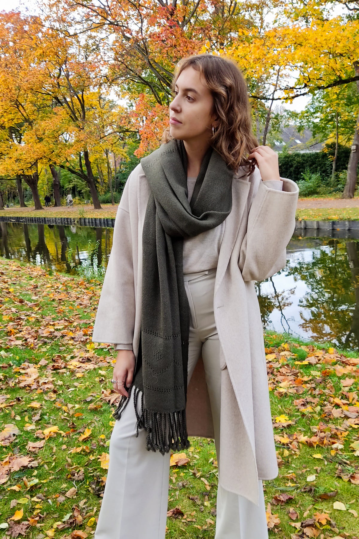 German woman wearing a wide green quetrupillan scarf with a laced pattern.