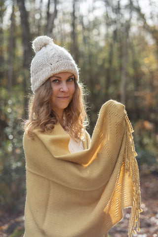 A woman using a yellow alpaca shawl