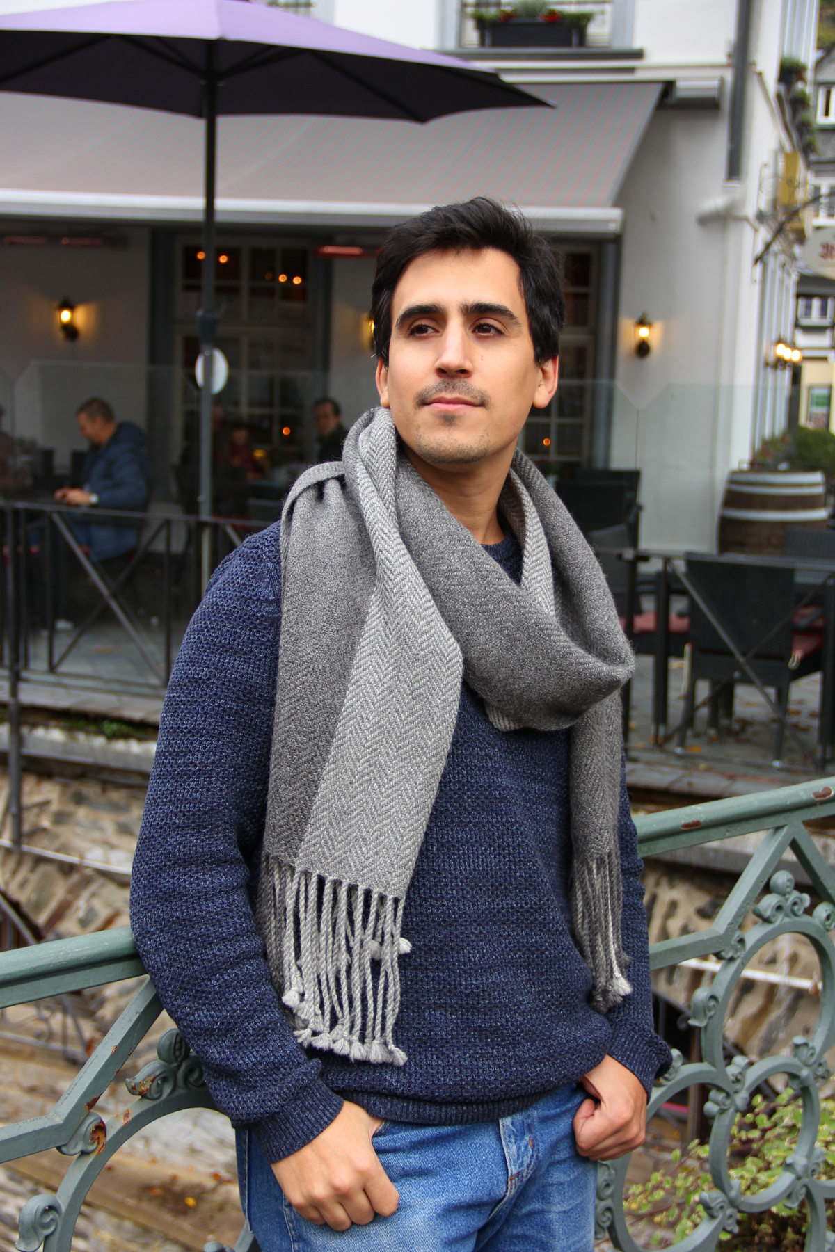 Latin American model with the wide ollagüe scarf in three shades of grey. Herringbone pattern and lined style.