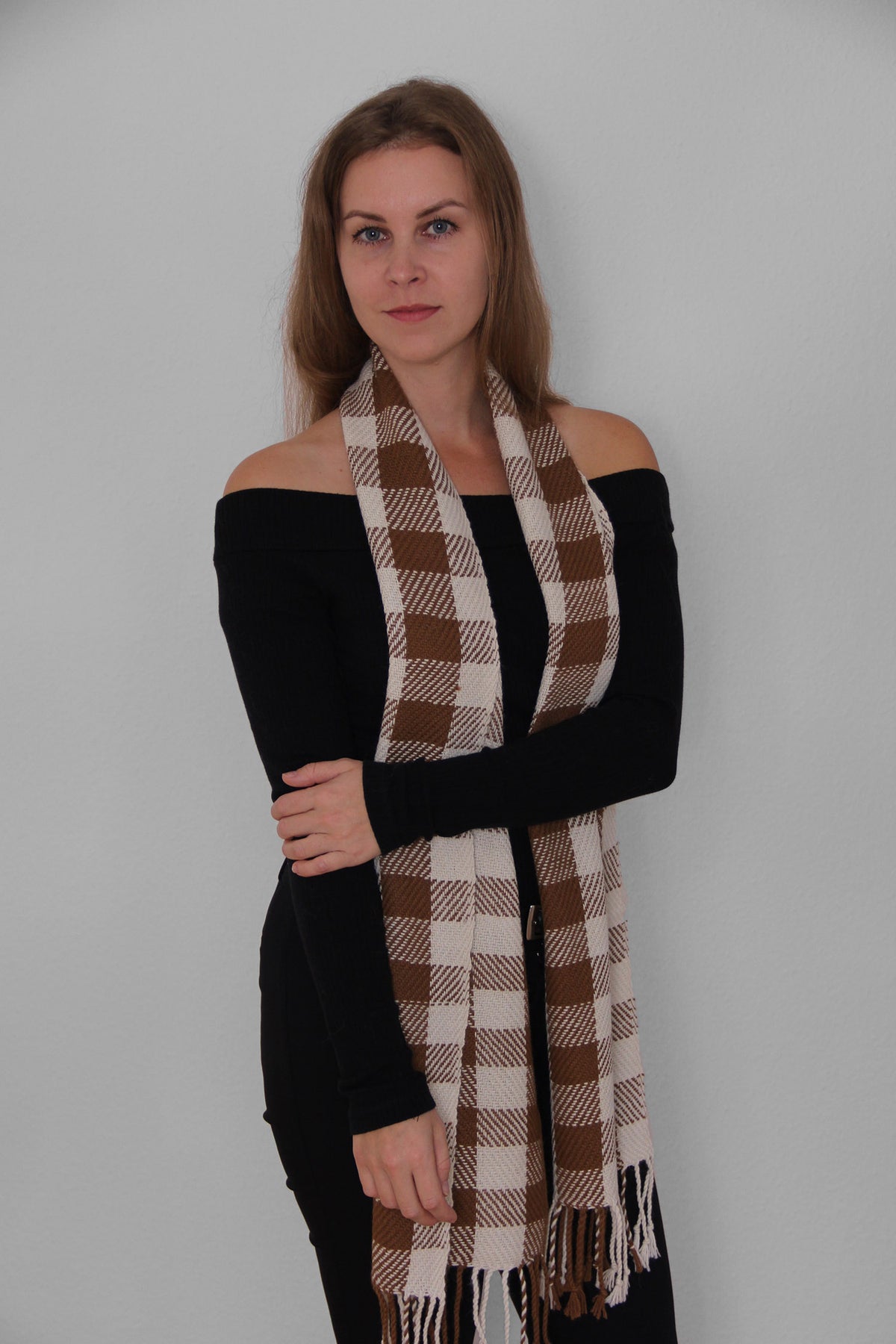 A woman using an Alpaca Scarf in brown and white colours.
