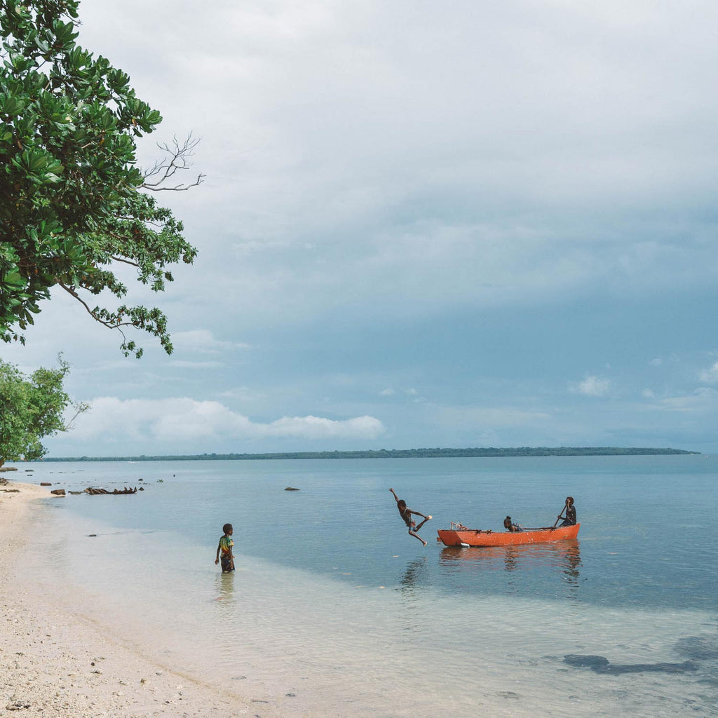 Stefan Haworth Photography. Vanuatu, kids playing in a traditional canoe on the beach