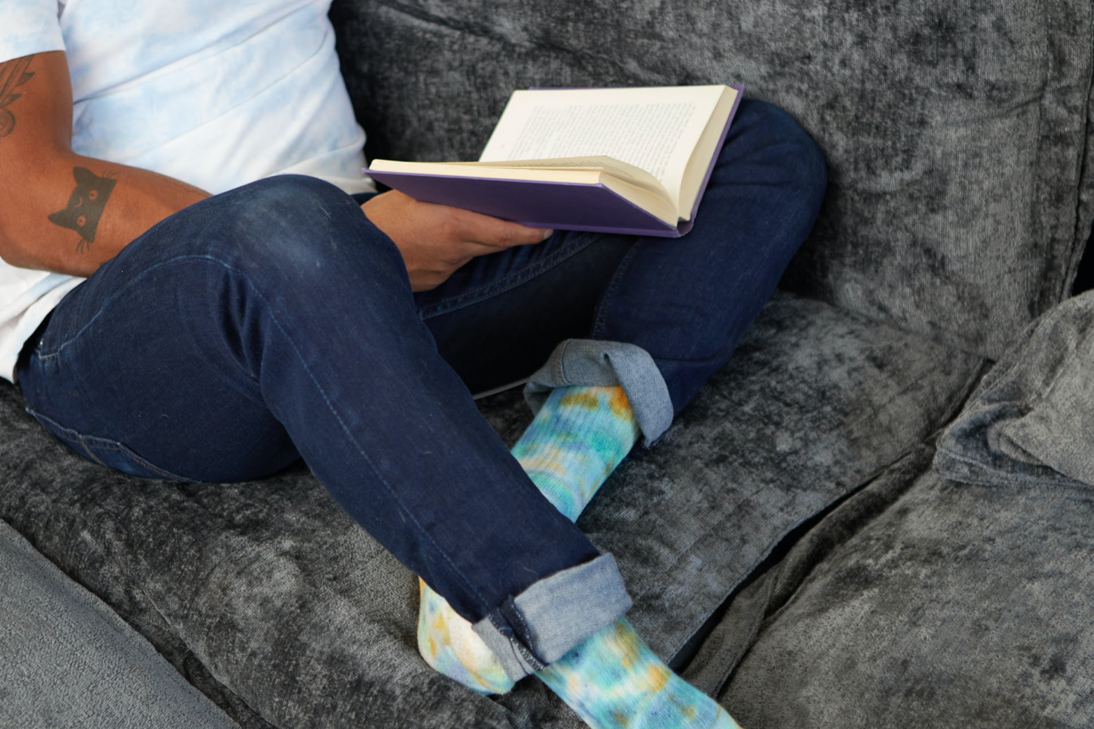 A man engrossed in a book while sitting on a couch.