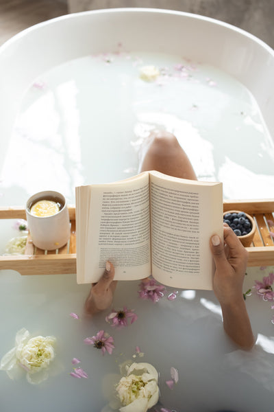 Woman reading book in bathtub during spa