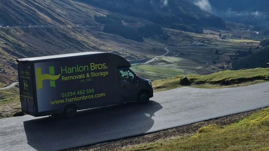 A Hanlon Bros van overlooking a scenic view in Scotland.