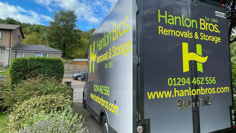 A Hanlon moving van in a driveway.