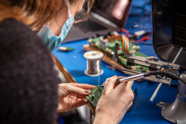 A woman works on a Printed Circuit Board