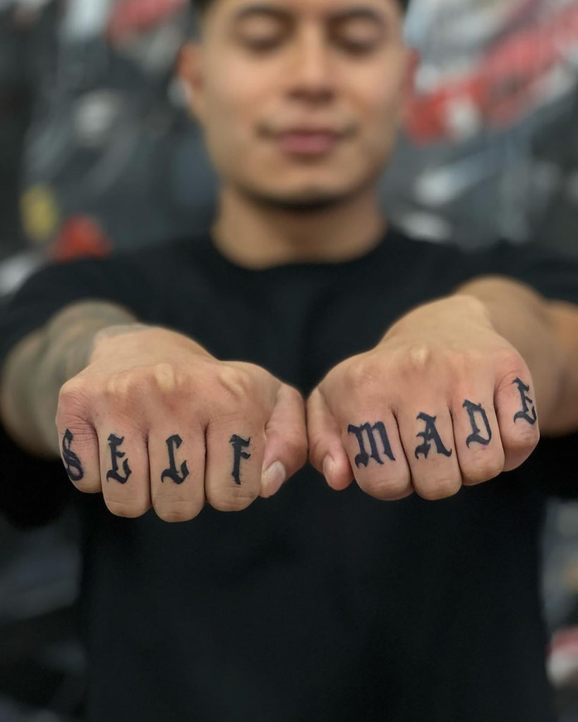 hand-poked unalome tattoo on thumb