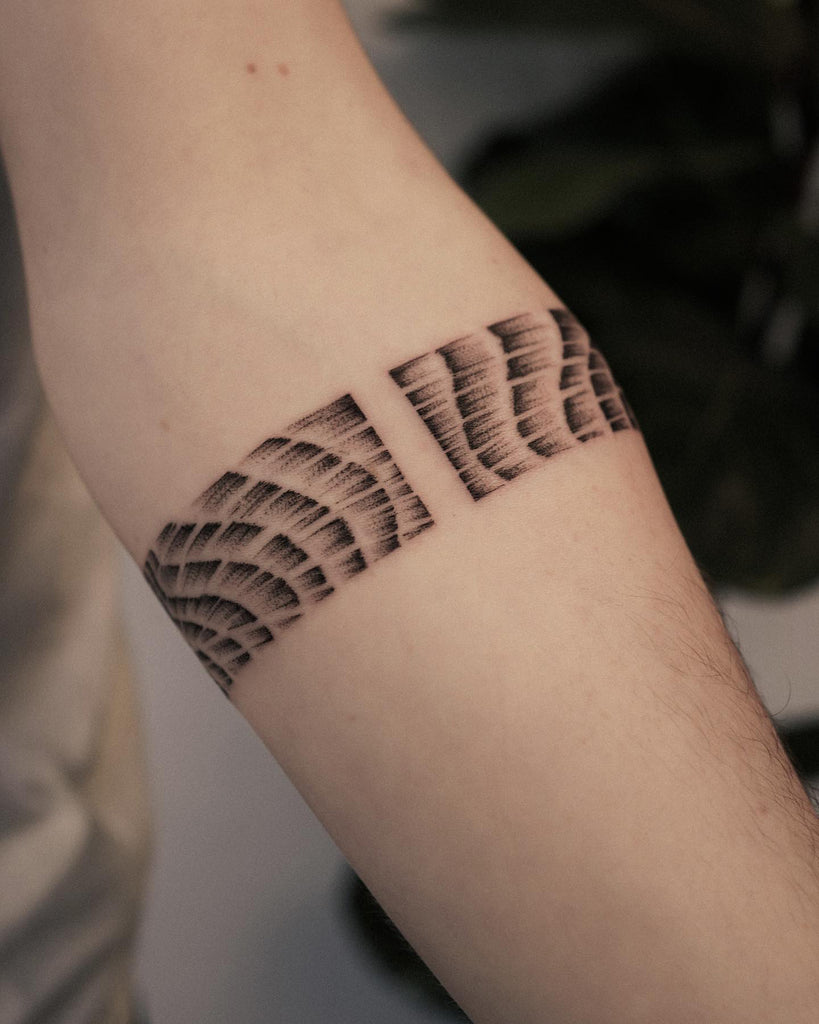 Fine line wave bracelet tattoo located on the upper