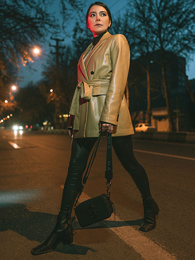 women in beige leather long coat with leather pants and ankle boots