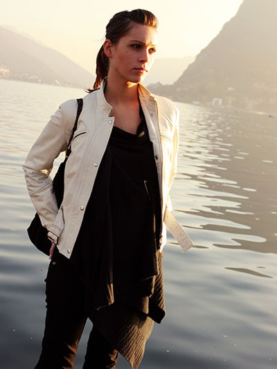 women in beige leather jacket and black leather pants, matching heeled sandals and a brown leather bag