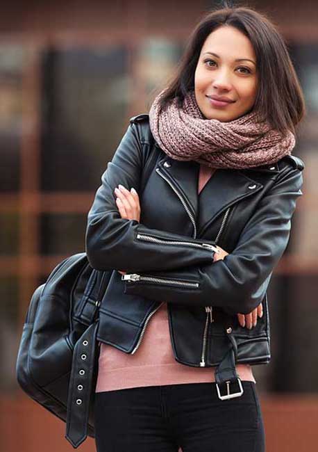 womens black biker leather jacket with peach sweatshirt and black jeans