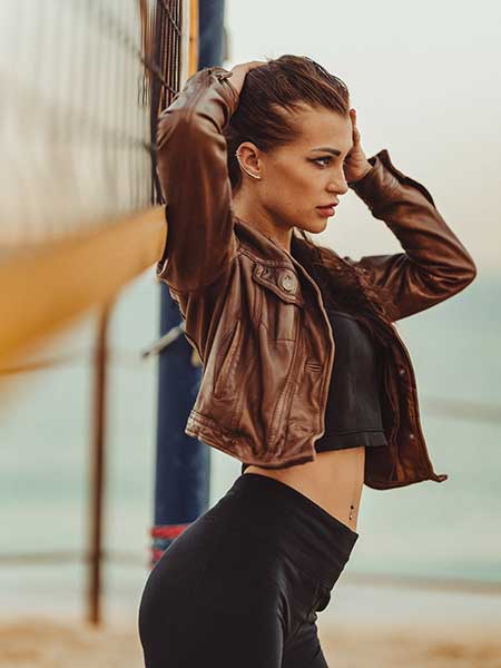 Women-brown-leather-jacket-with-black-cropped-blouse-and-black-leggings