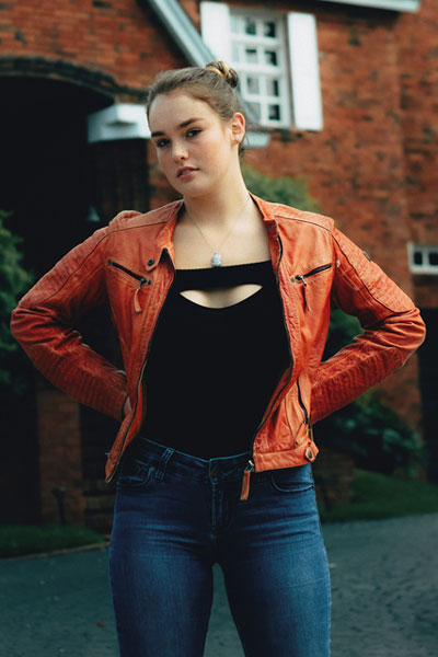 Women-organge-leather-jacket-with-skin-tight-jeans-and-black-top 