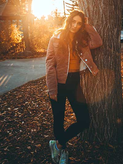 women-tan-leather-jacket-with-black-jeans-and-cropped-blouse