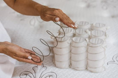 pocket coils of a mattress being demonstrated by a person