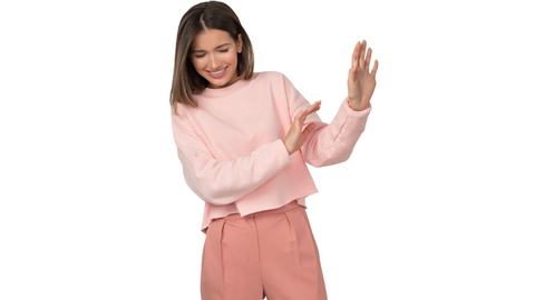 woman wearing pink shirt and pink pants, standing with her hands up