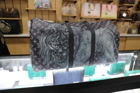 A grey Louis Vuitton bag with a tiger graphic on display at Max Pawn.
