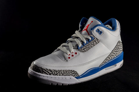Conclusion - A modern pair of blue, white, grey and red Air Jordans is photographed with a dark background.