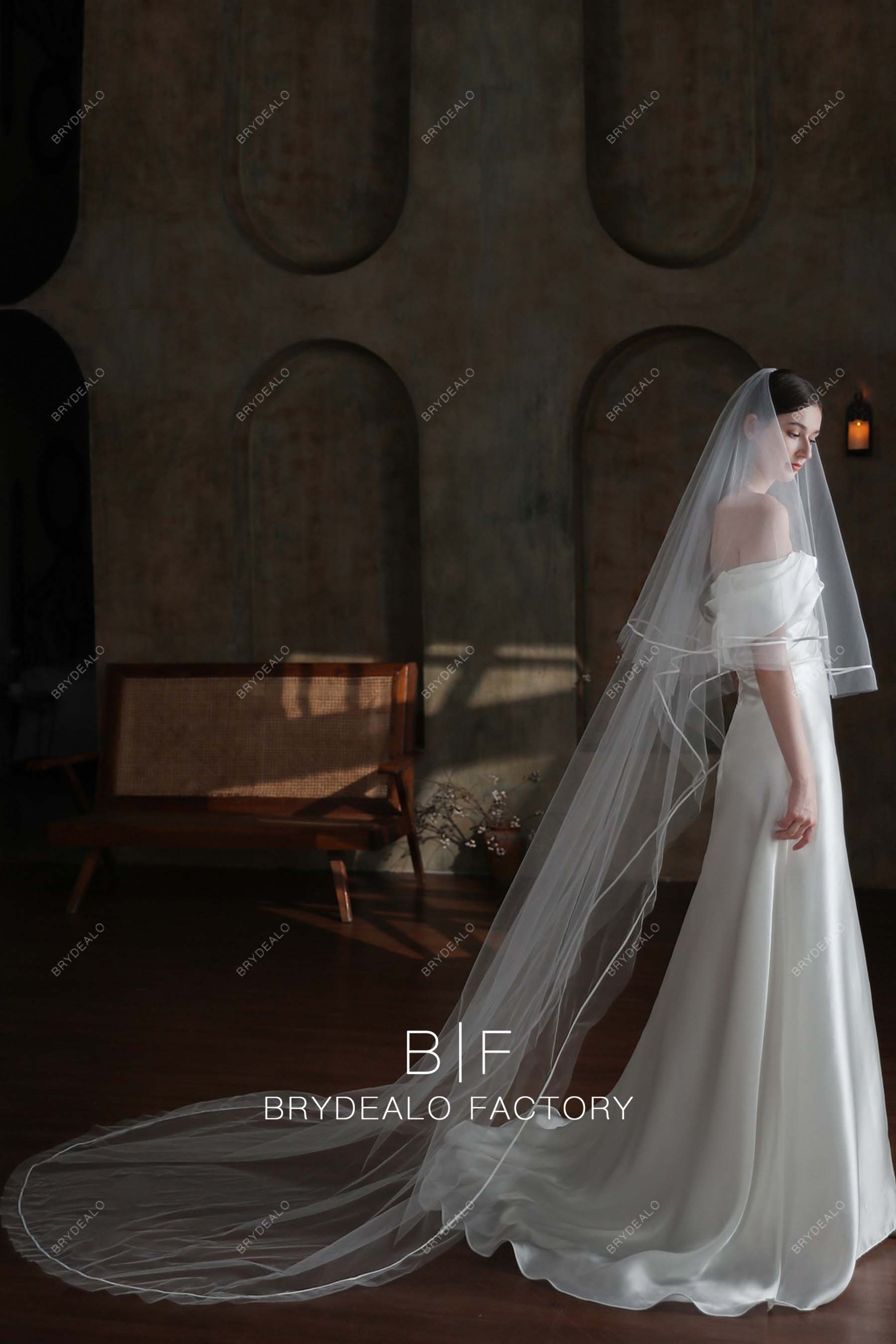 https://cdn.shopify.com/s/files/1/0558/7599/3647/files/cathedral-length-satin-ribbon-two-tiered-bridal-veil-08170.jpg?v=1697004441&width=1800