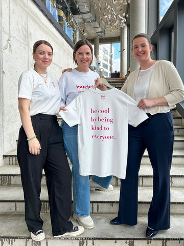 Auf dem Bild sind drei Frauen zu sehen. Edda und Sarah von isociety. Und Michaela von DS Info Center. Sie zeigen ein T-Shirt von der barbie x isociety Kooperation.