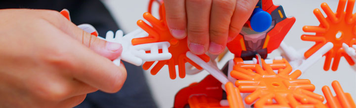 A child's hand playing with a Dexor STEM authenticated action-themed building set available at Luki Lab.
