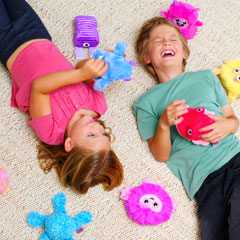 Kids on the floor playing with House Monsters plush available at Luki Lab.