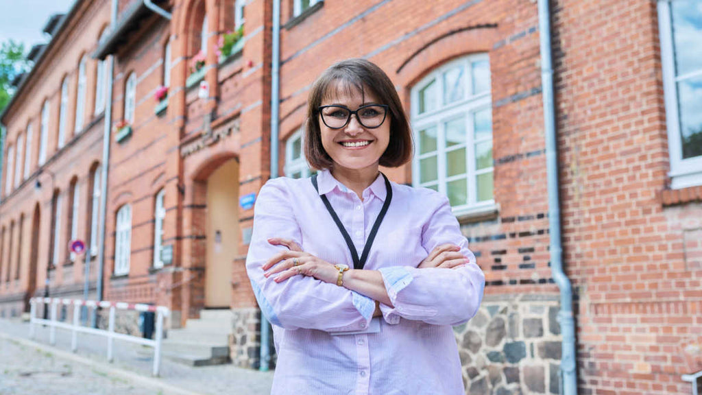 successful teacher with many great years to come standing outside her school