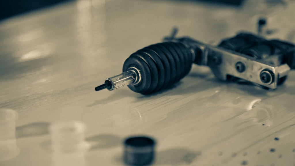 A tattoo gun laying on a table. 