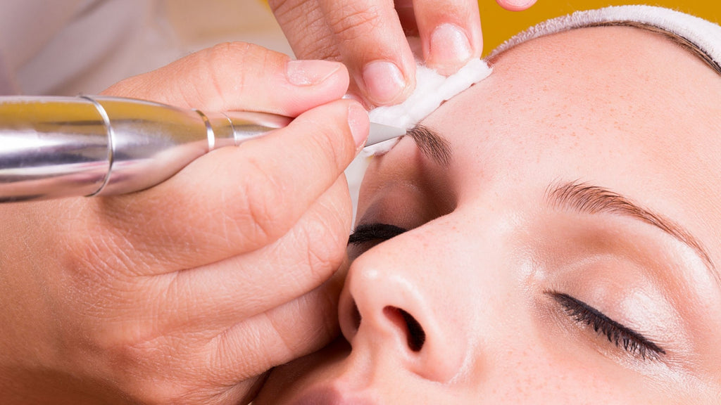 A lady getting an eyebrow tattoo.