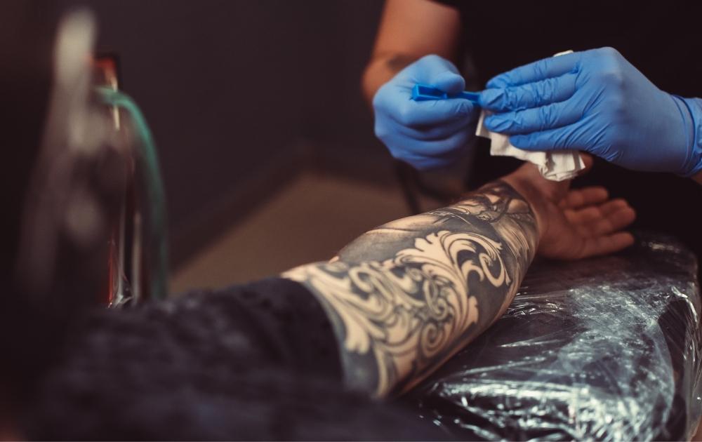 An artist busy covering up a tattoo. 