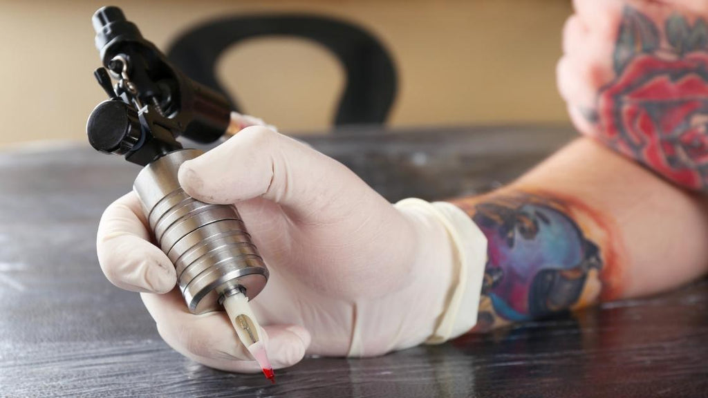 An artist holding a tattoo machine. 