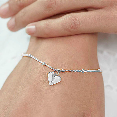 Model wearing silver heart bracelet