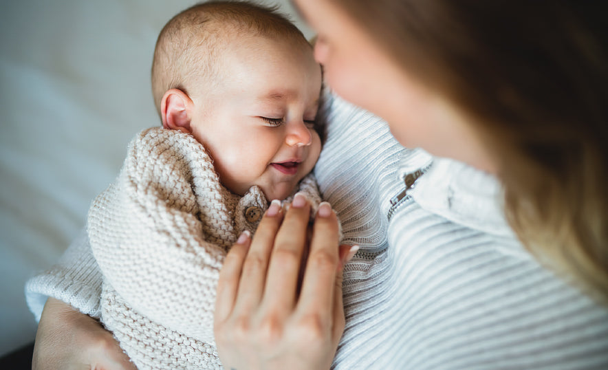 A mom is swaddling her baby