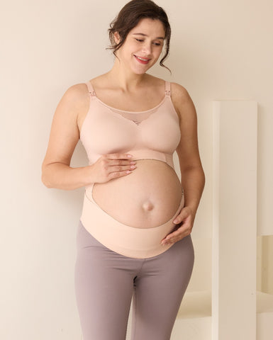 Pregnant woman wearing a supportive maternity belly band.