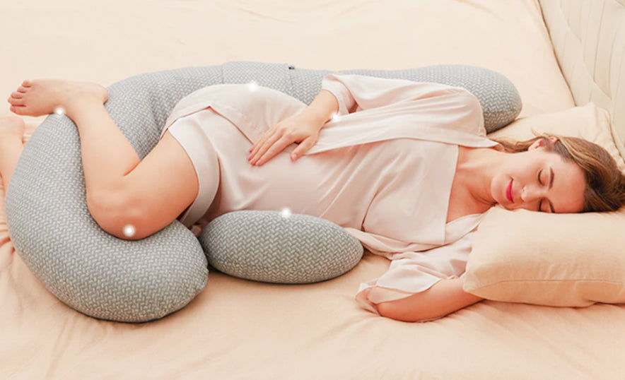 Une maman dormant dans un oreiller de grossesse momcozy