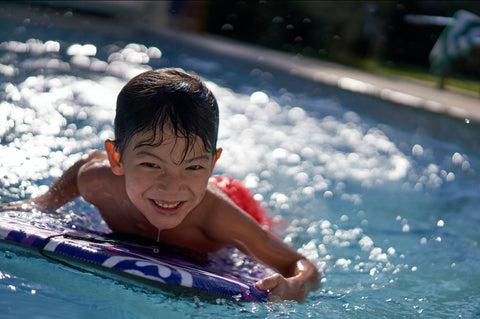 little boy swim lessons kick-board learn to swim