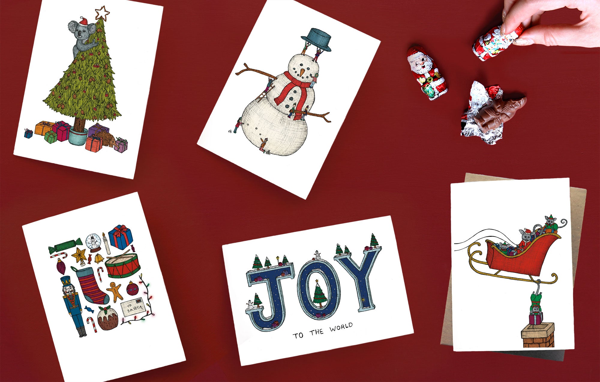 Flat lay of 5 assorted Christmas cards on red background