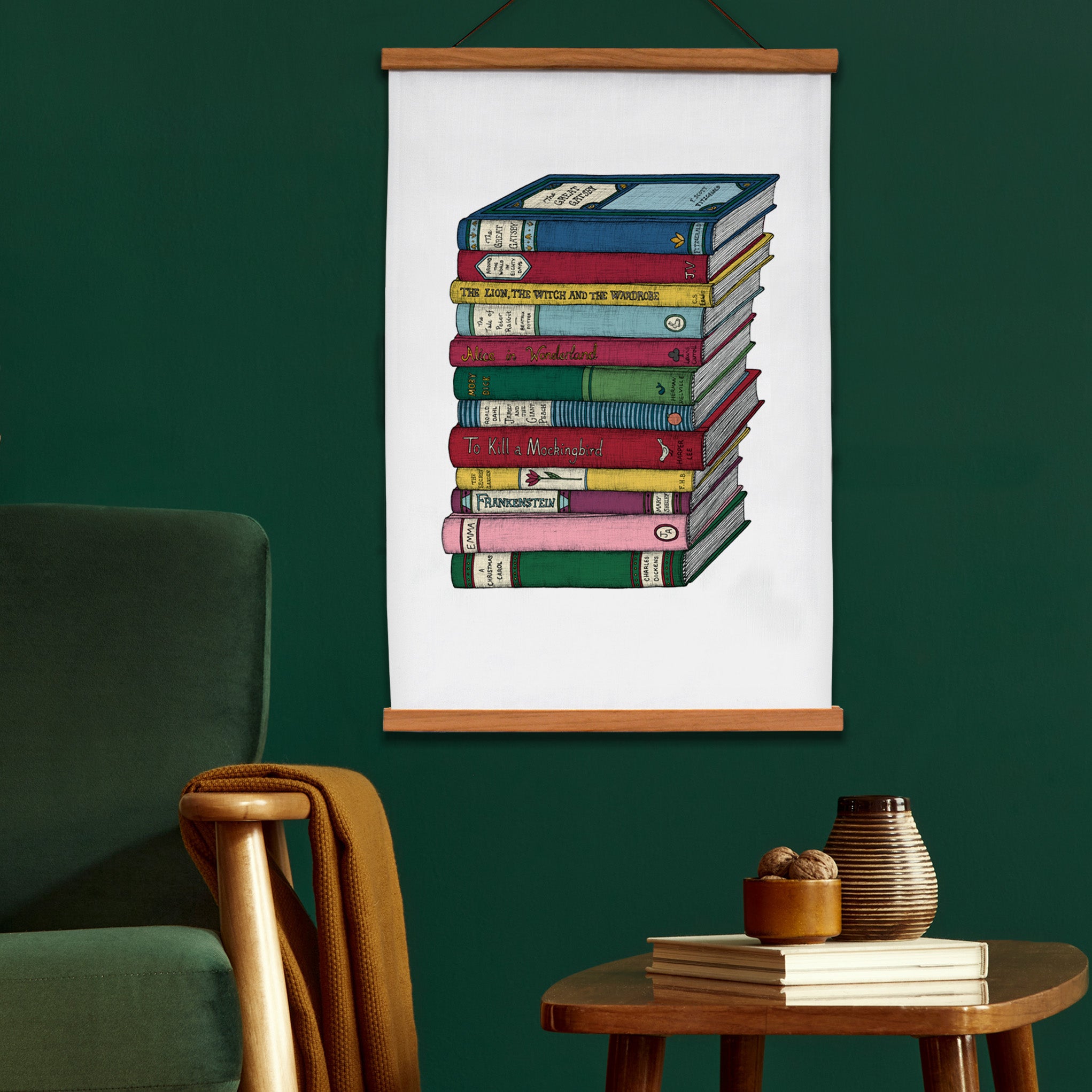 Book Lovers art tea towel framed and hanging on a green wall.